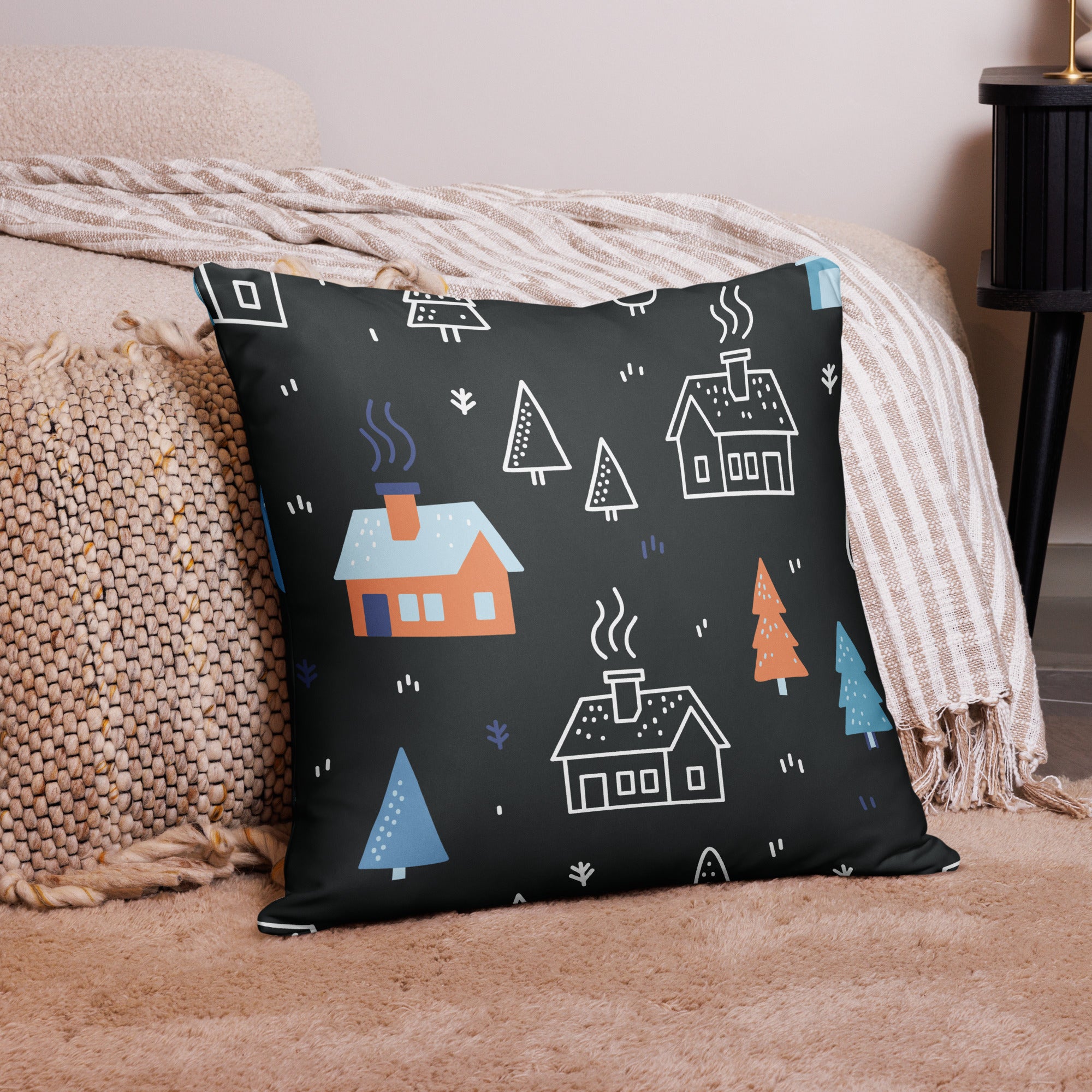 Back side of the oversized holiday pillow featuring minimalist cabin and tree designs on a dark background.