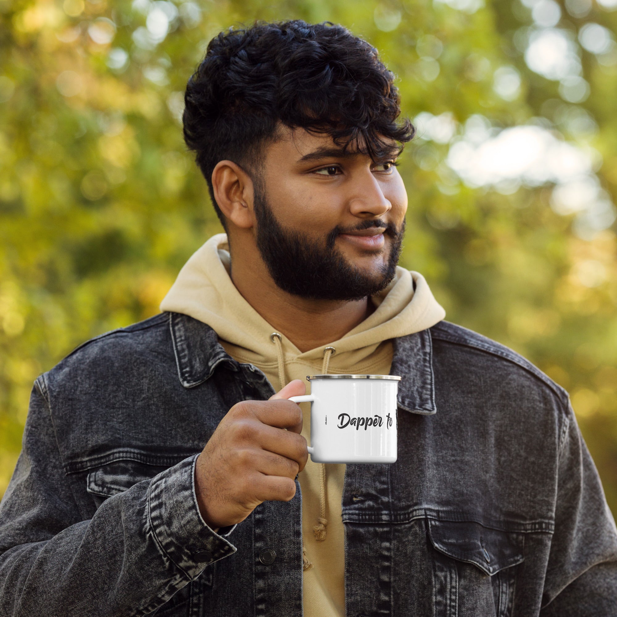 Man enjoying a drink outdoors with the "Dapper to the Grave" enamel mug in hand.