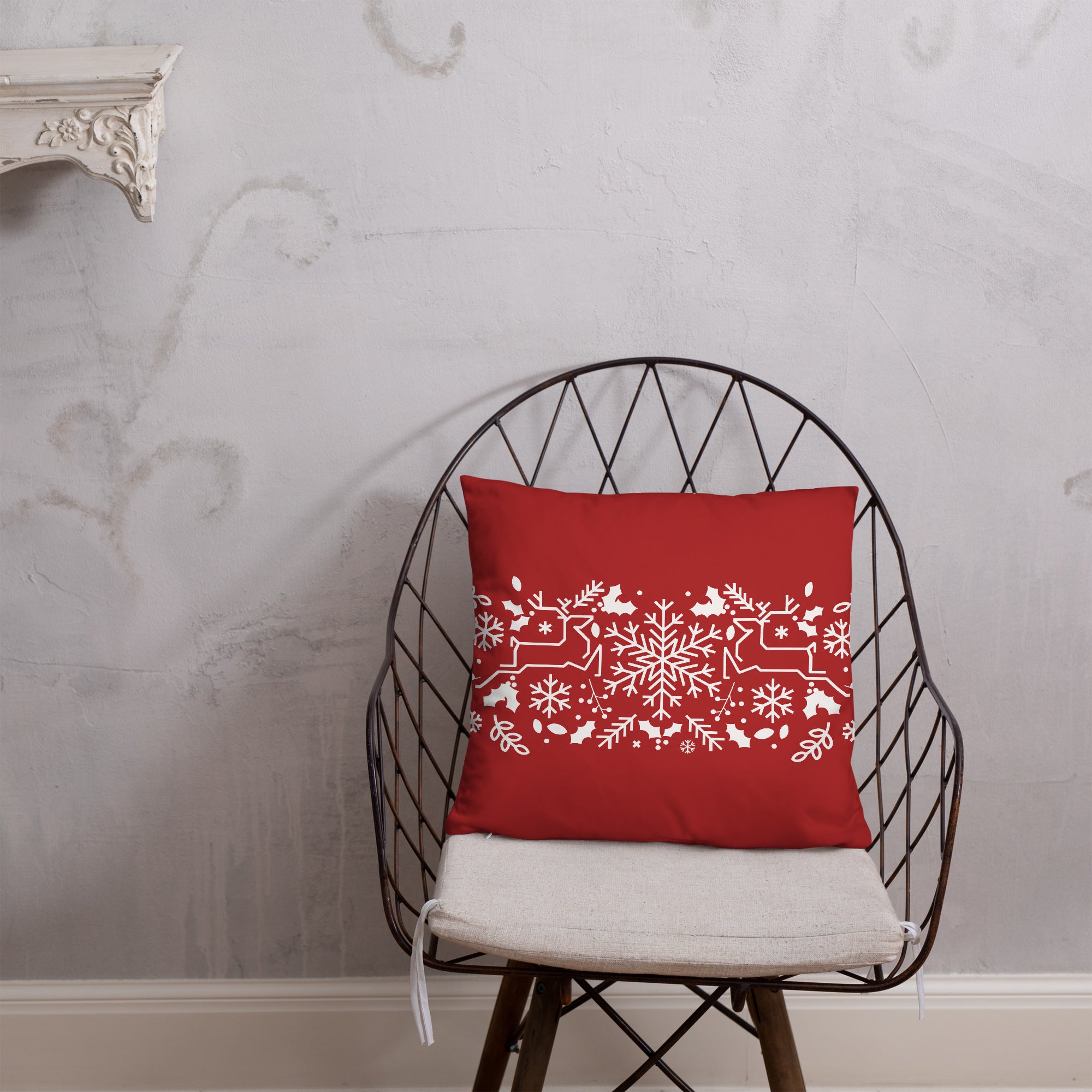 Christmas-themed throw pillow with a vibrant red and white festive design, shown on a chair.