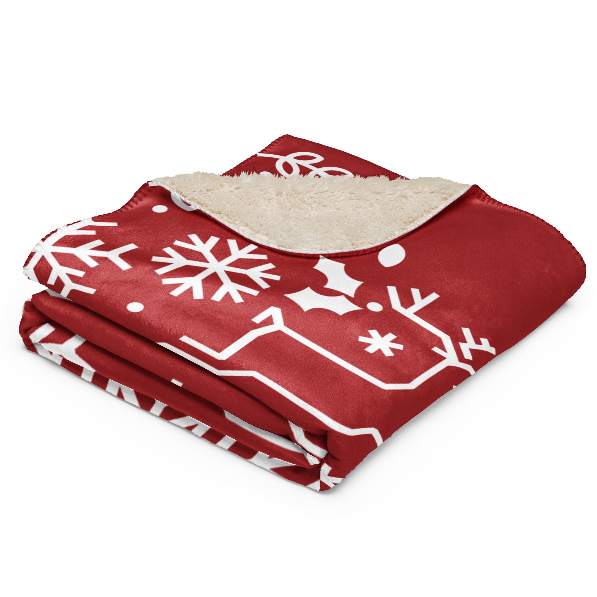 Folded red sherpa blanket showcasing a white festive design and cozy sherpa lining.