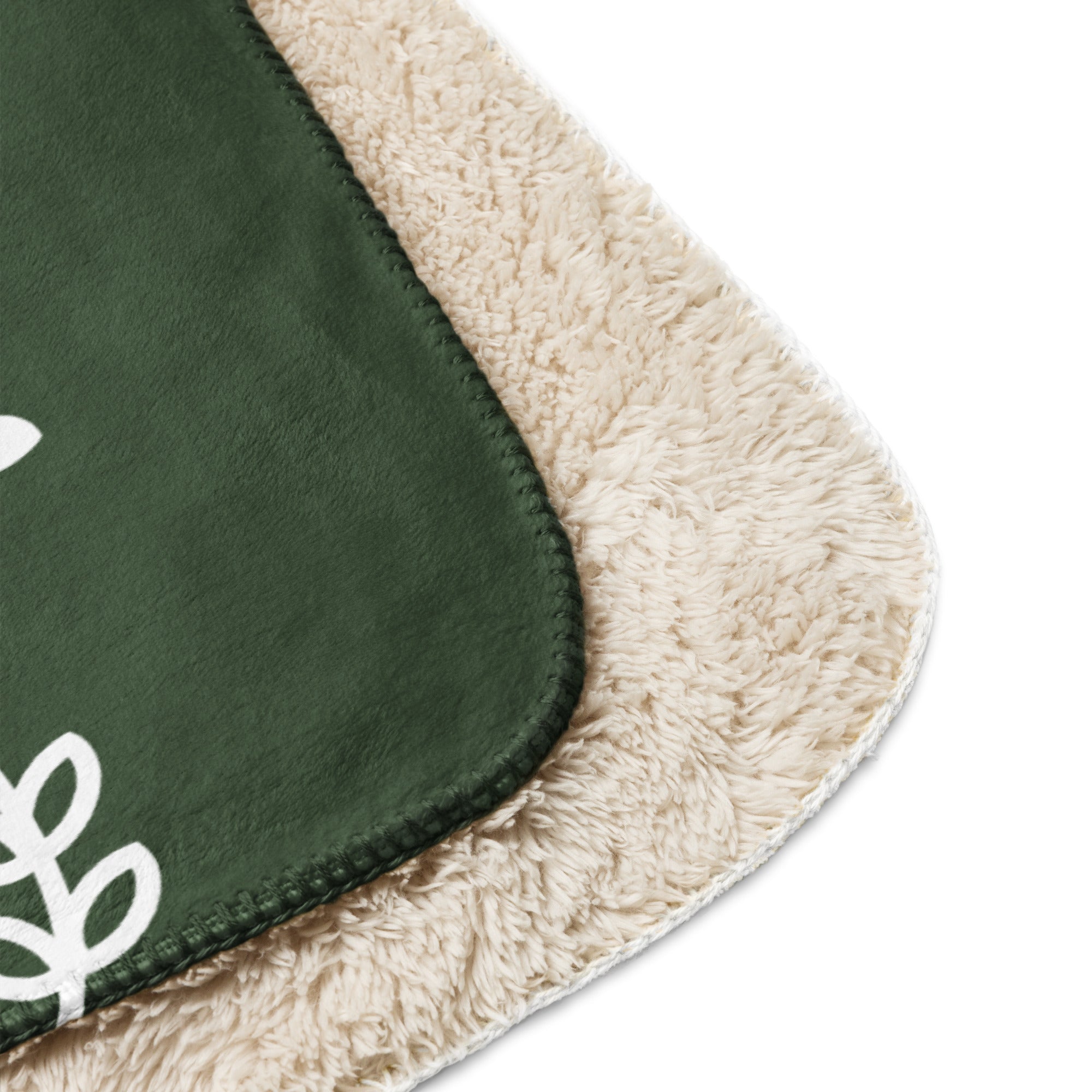 Close-up of Forest Green Sherpa Blanket’s edge with festive snowflake design, showcasing its durable stitching and soft texture.