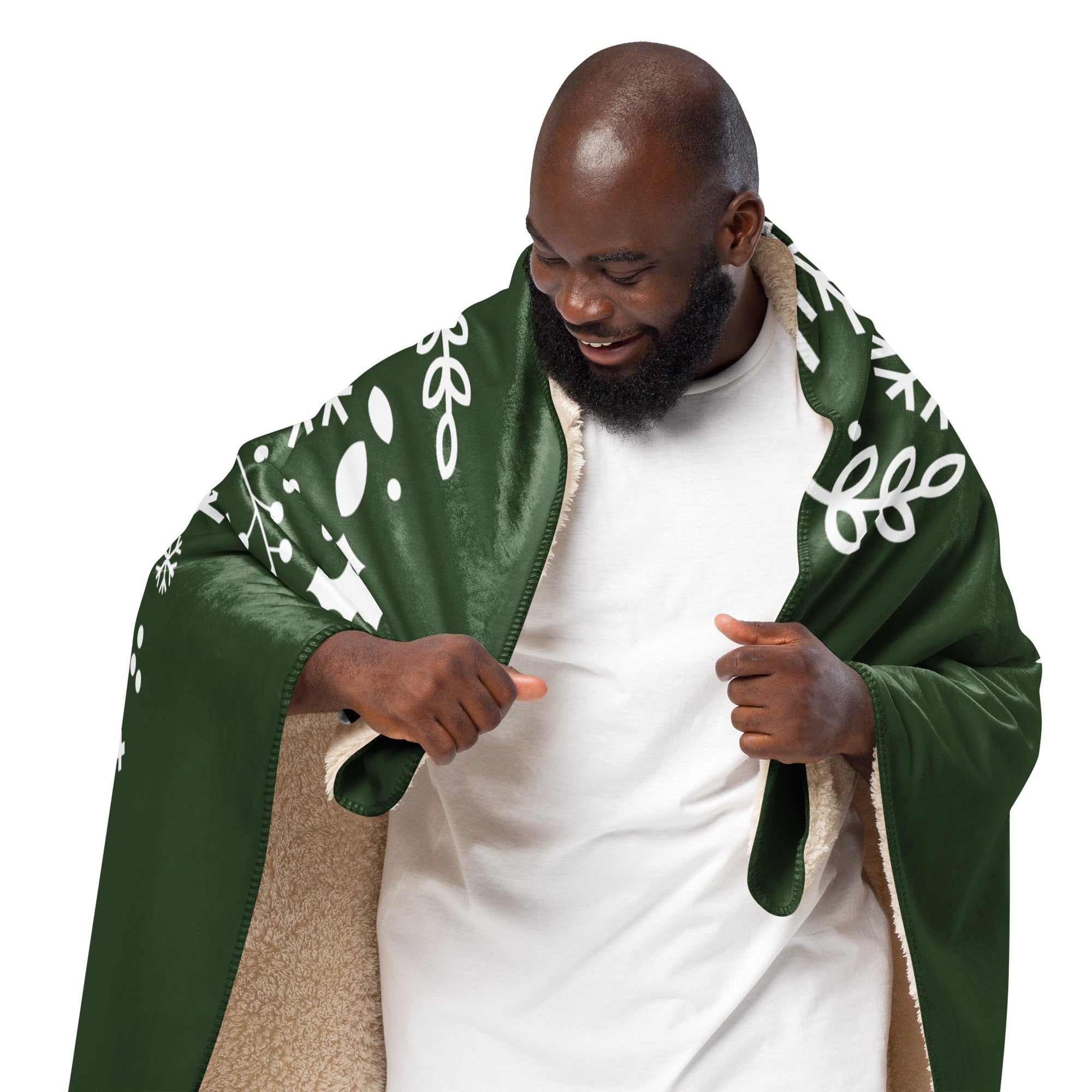 Man wrapped in a Forest Green Sherpa Blanket featuring snowflakes and holly, showcasing the plush comfort and festive design.