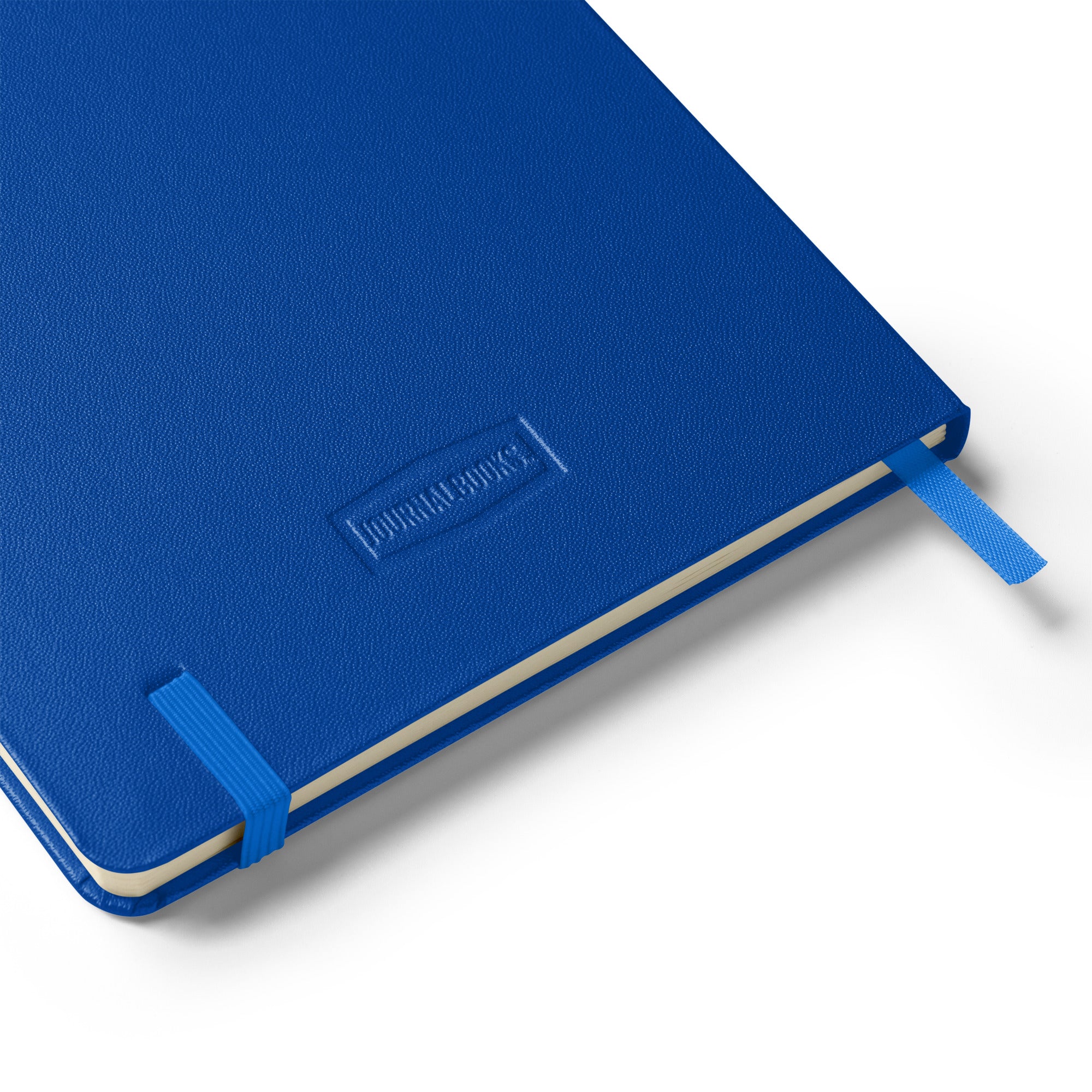 Close-up of the blue "TACOS!" UltraHyde notebook back cover with embossed "JournalBooks®" logo and matching blue elastic band.