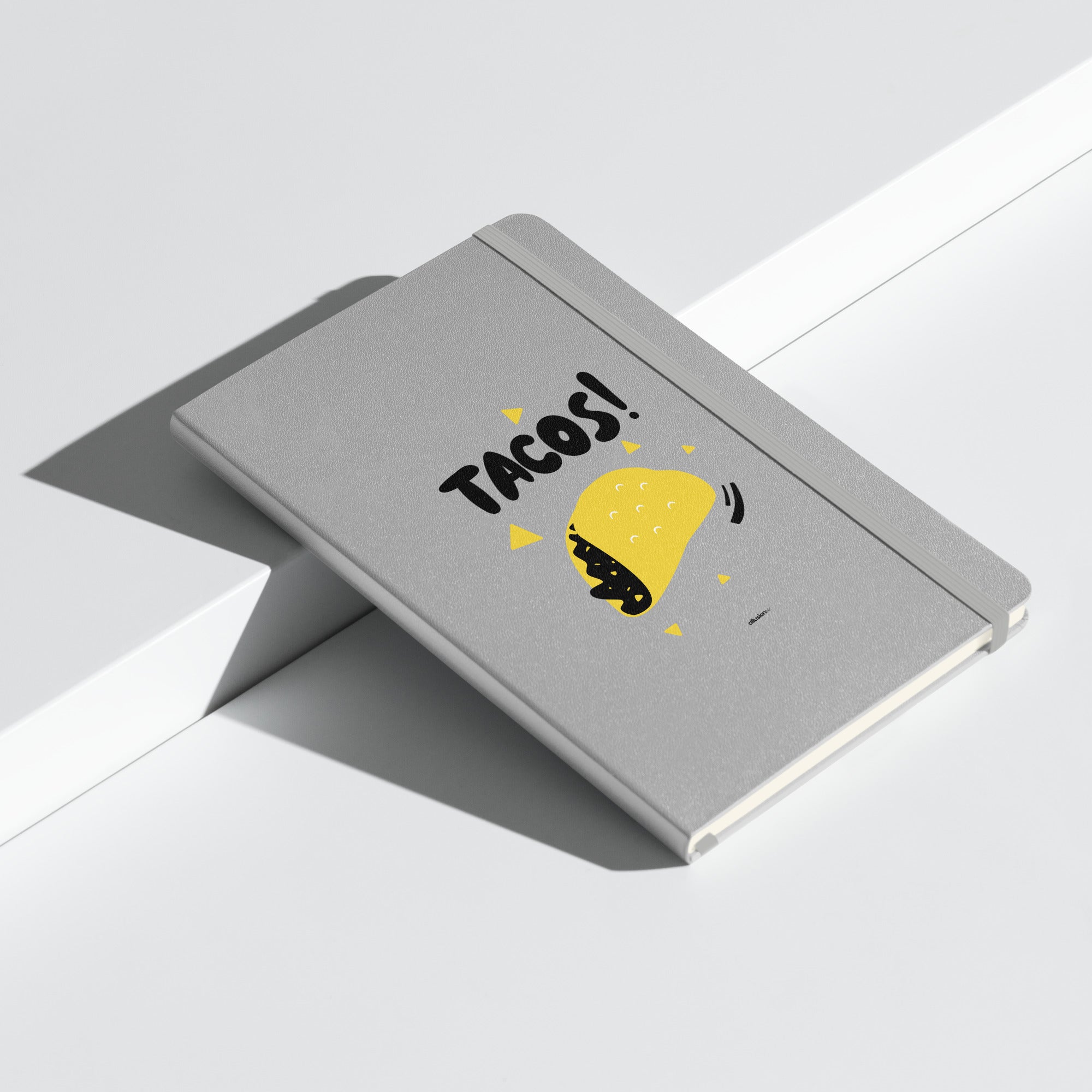 Silver hardcover UltraHyde notebook with bold "TACOS!" design and a yellow taco illustration.