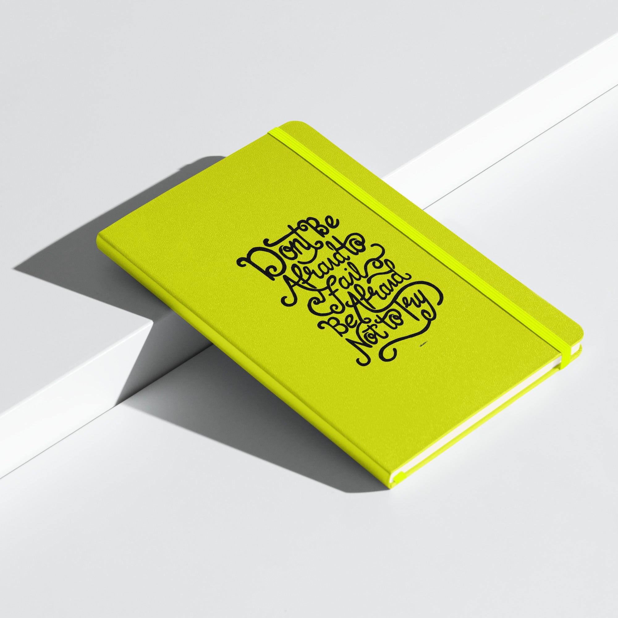 Lime green inspirational notebook with the quote 'Don't be afraid to fail, be afraid not to try' on the cover.