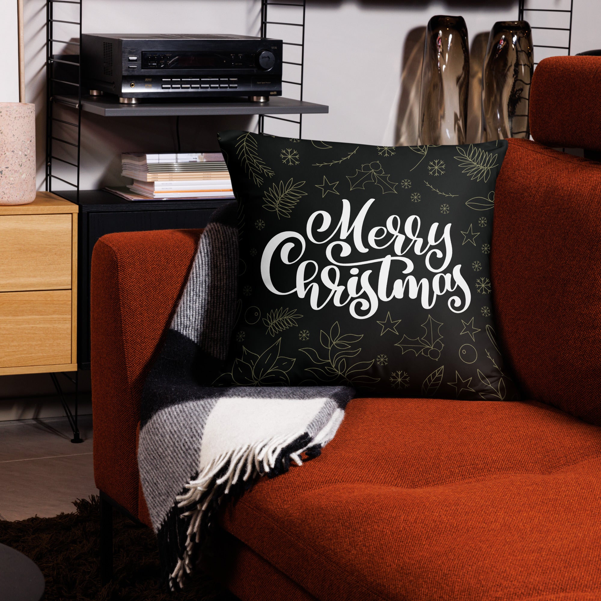 Front view of a larger holiday pillow with 'Merry Christmas' lettering and festive gold patterns, adding seasonal charm to any living room.