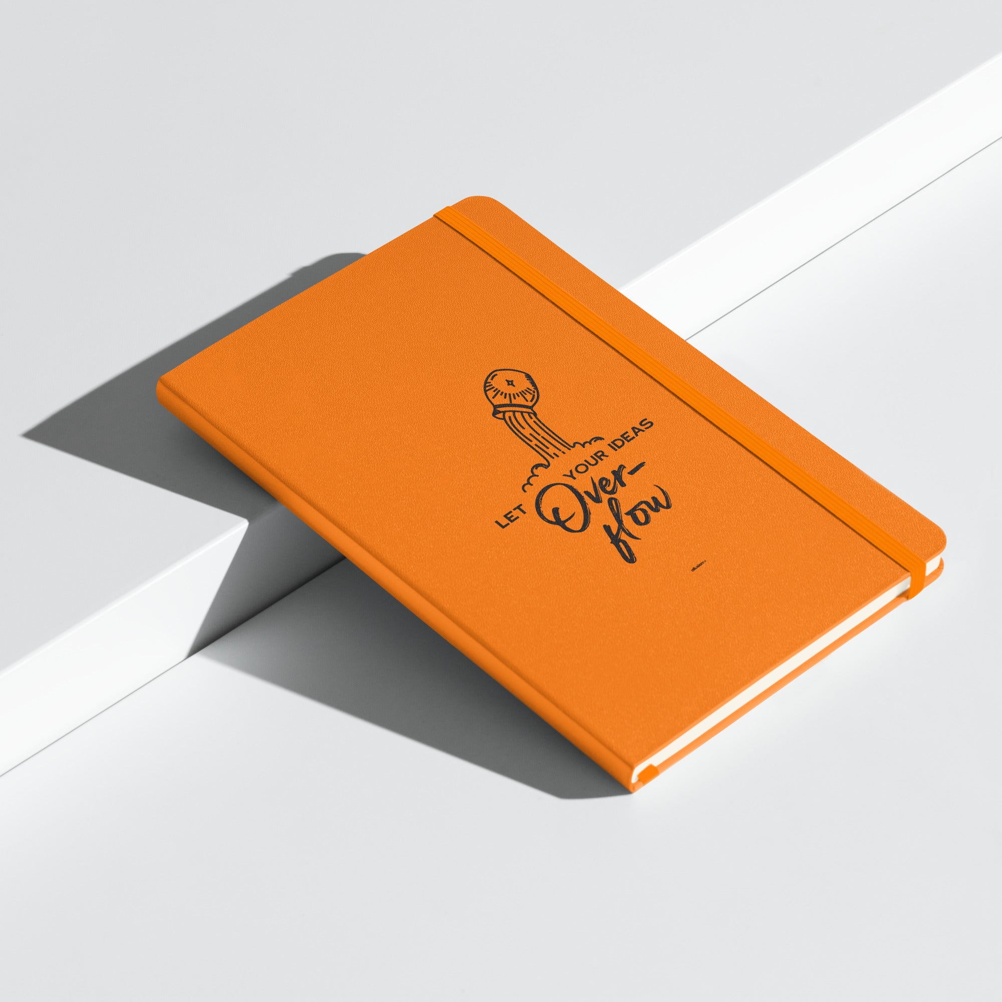 Orange hardcover notebook with 'Let Your Ideas Overflow' design, displayed at an angle.