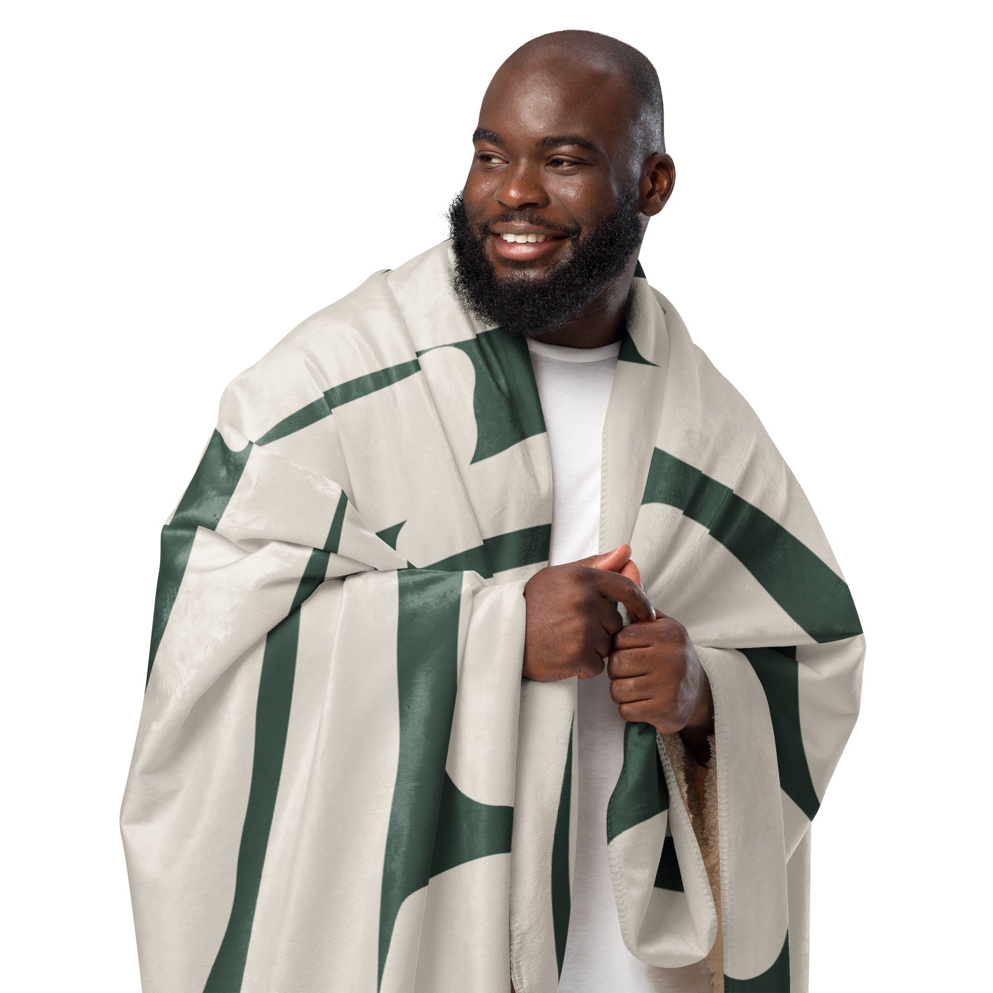 Man wrapped in a cozy green and beige sherpa blanket with botanical-inspired design.