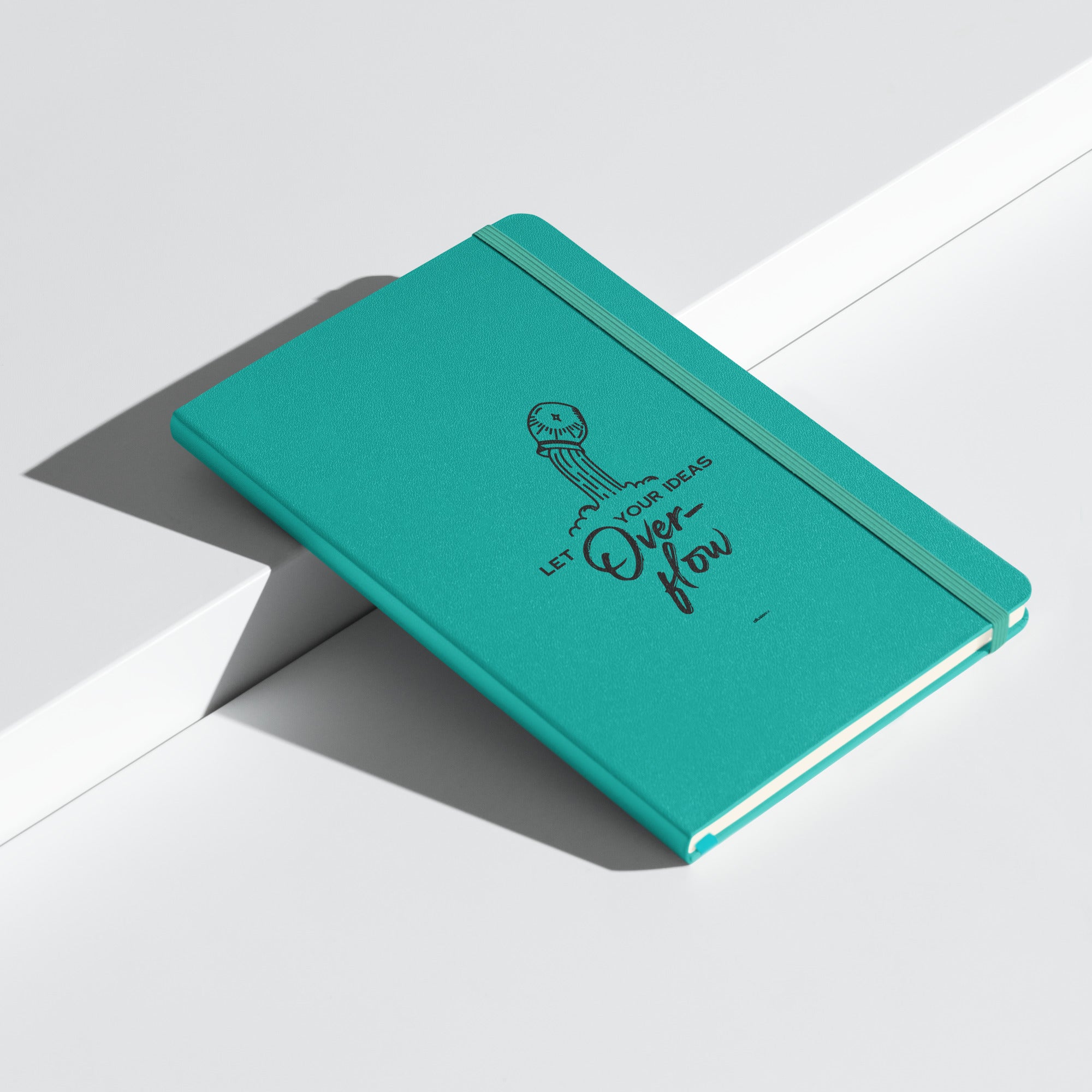 Hardcover turquoise journal with "Let Your Ideas Overflow" design, placed on a white modern background.