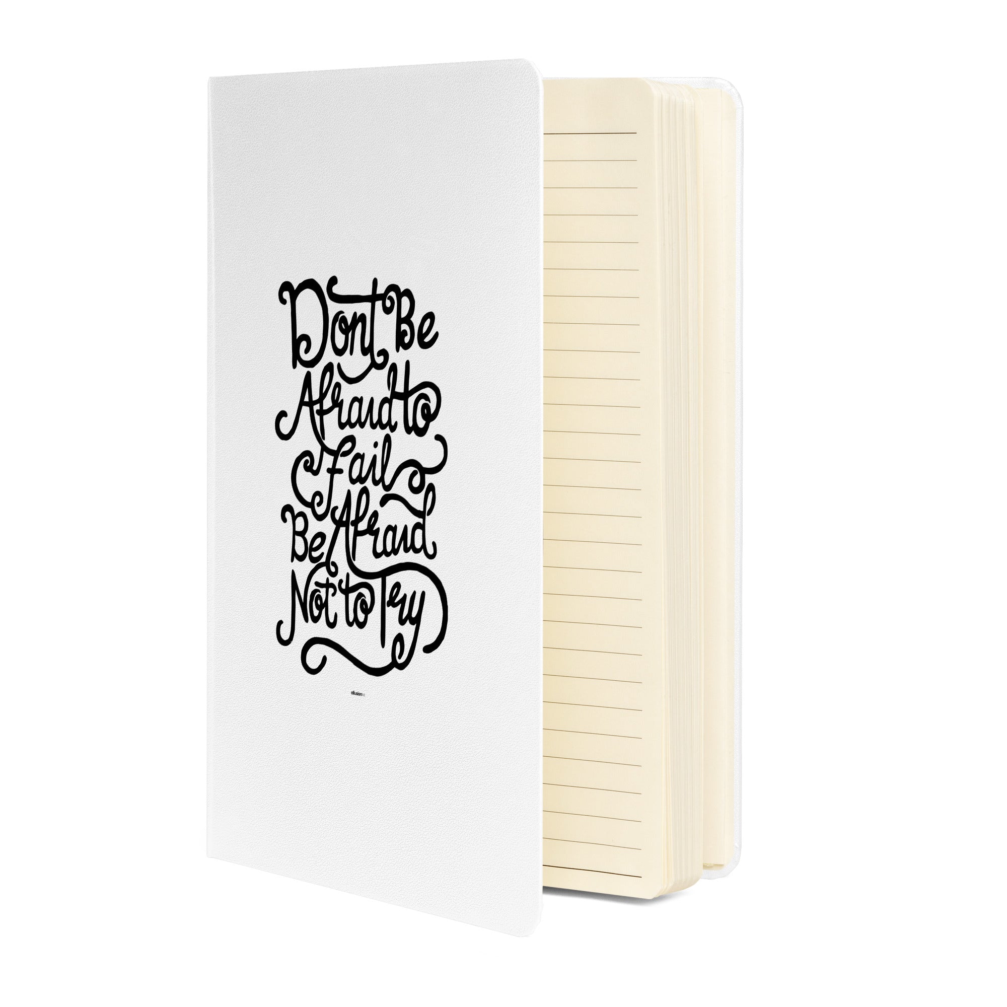 White hardcover notebook with the quote 'Don't be afraid to fail, be afraid not to try' and lined pages inside.